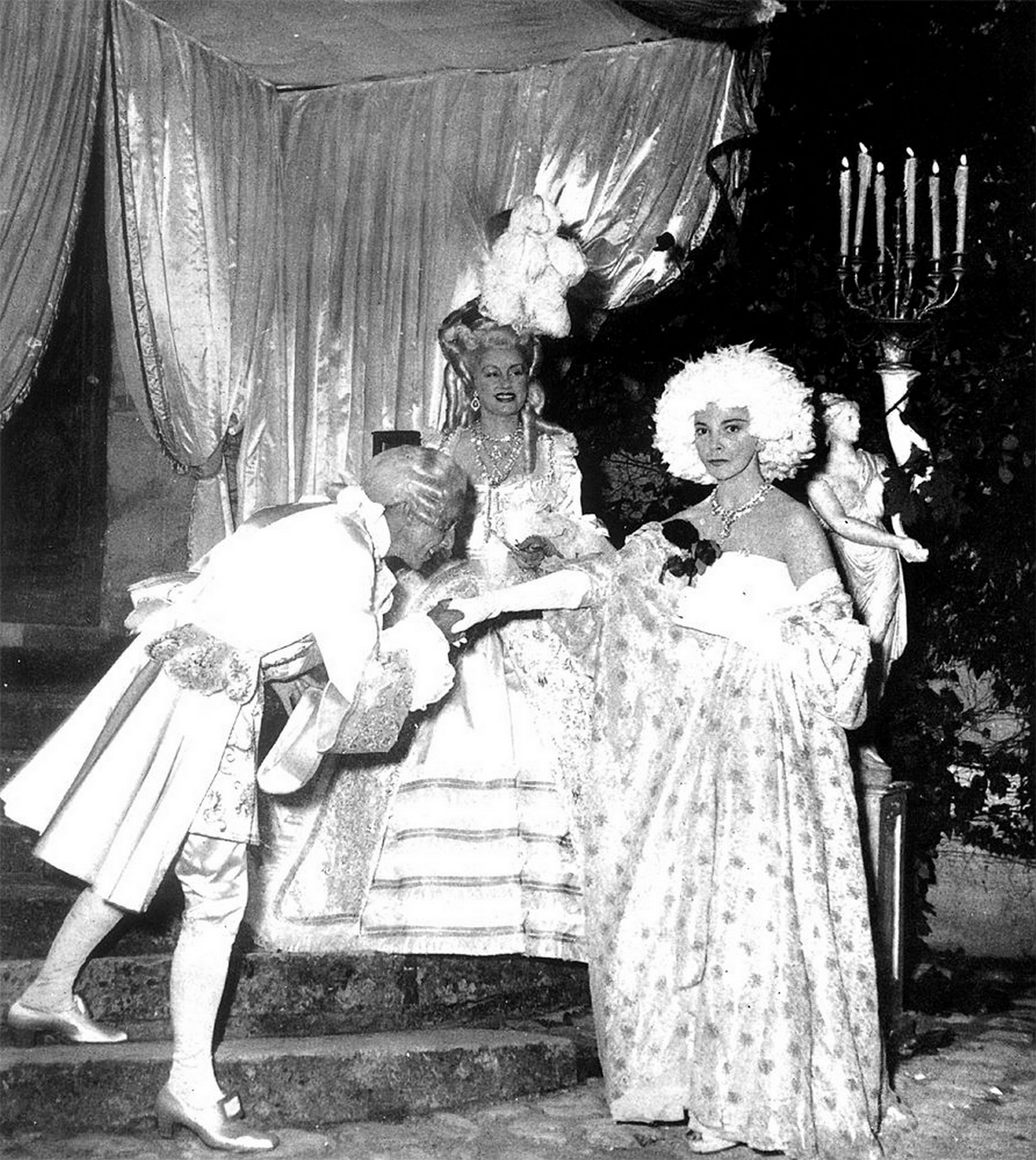L’un des fameux bals costumés que Jacques Fath donnait chaque année dans son château de Corbeville, dans les Yvelines (Ici, le bal Blanc de 1951, avec Jacques Fath déguisé en comte d’Artois, sa femme Geneviève Fath (née Geneviève Boucher de La Bruyère) en Marie Antoinette et Léonor Fini en Mme de Pompadour).<br><br>