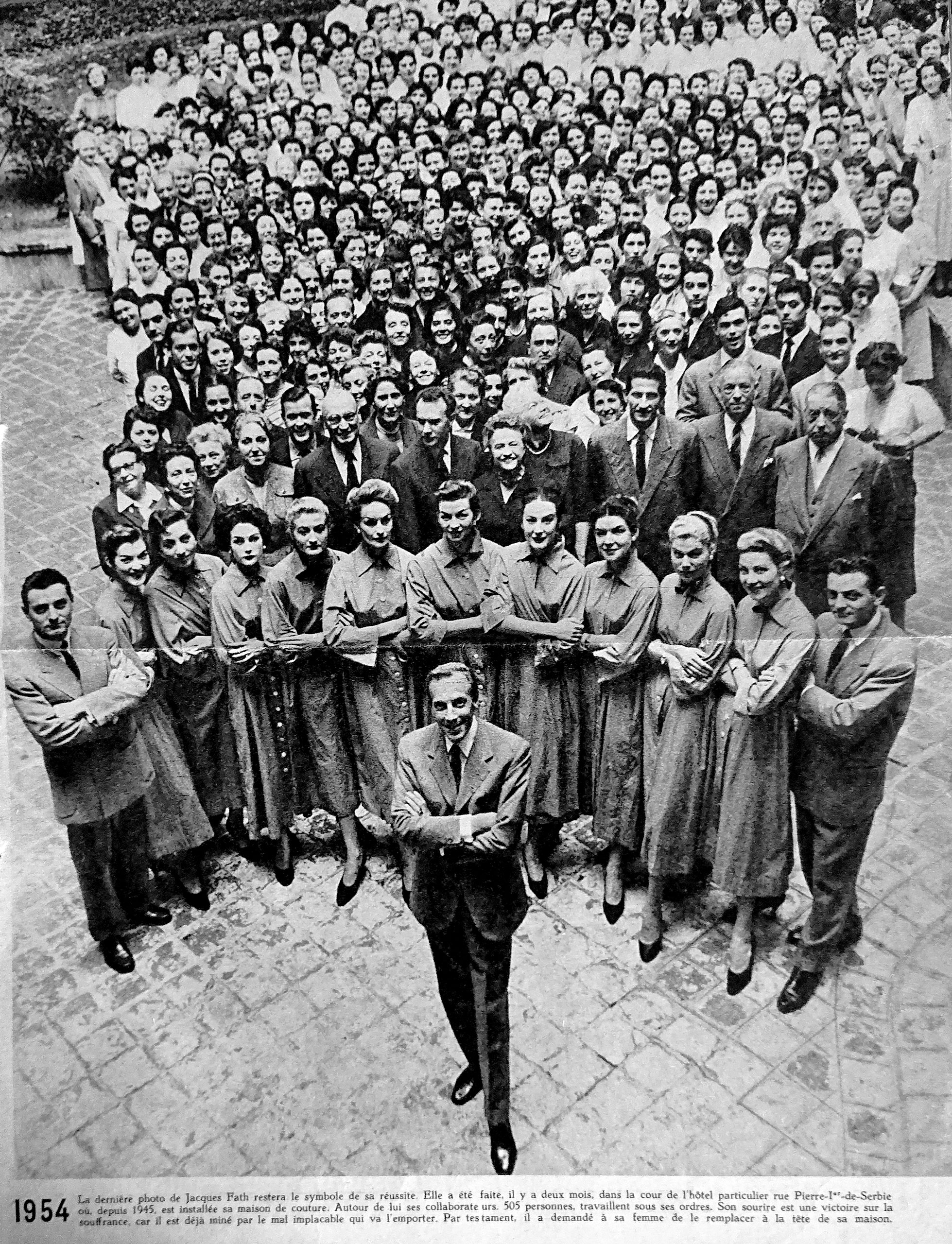 Jacques Fath posant peu avant sa mort avec tous ses employés réunis dans la cour de son hôtel particulier de l’avenue Pierre 1er de Serbie, siège de sa maison de couture (mais toujours pas de Marcelle Pichon parmi les mannequins figurant au premier rang !). <br><br>